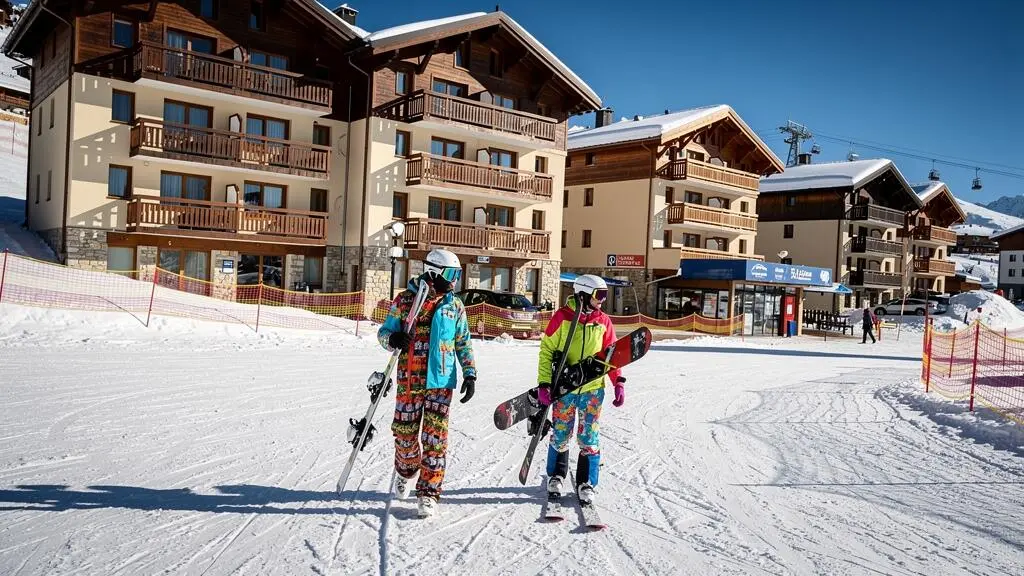 Skieurs retournant à leur résidence au pied des pistes à La Plagne avec bâtiments d'appartements en accès direct